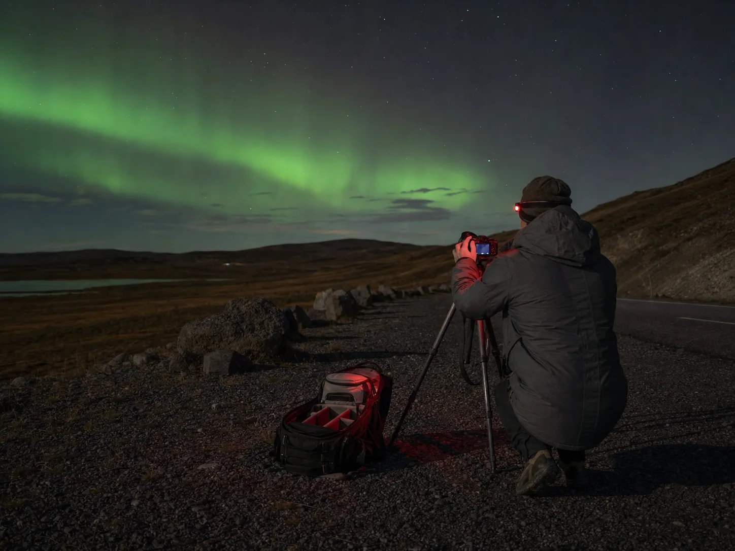 An AI-created aurora observer preparing a tripod beside a dark road